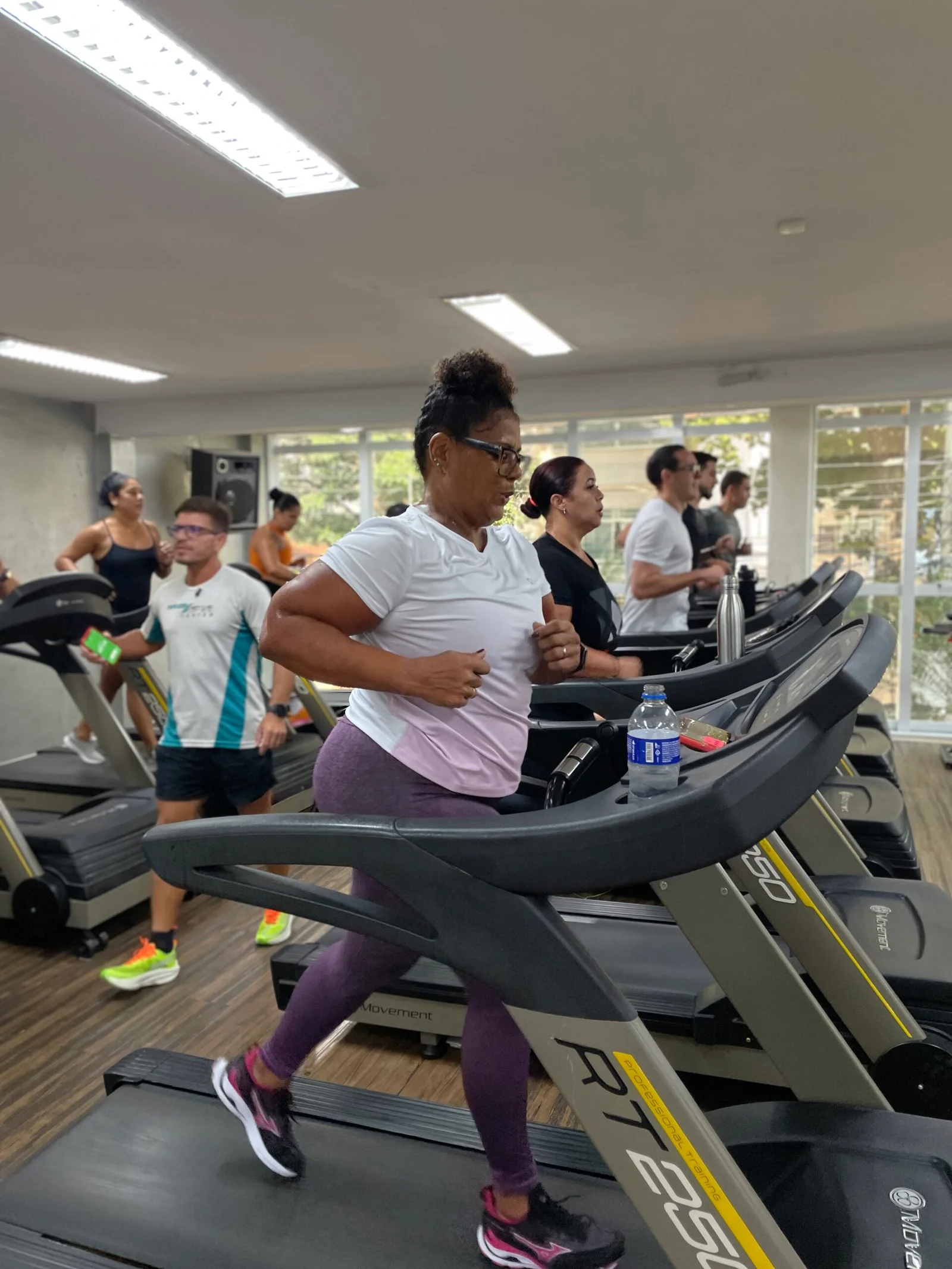 Alunos treinando nas esteiras da MaxFit, com a equipe presente no salão.
